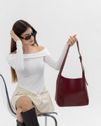 Sac hobo noir à épaule, boucle dorée, aspect cuir lisse