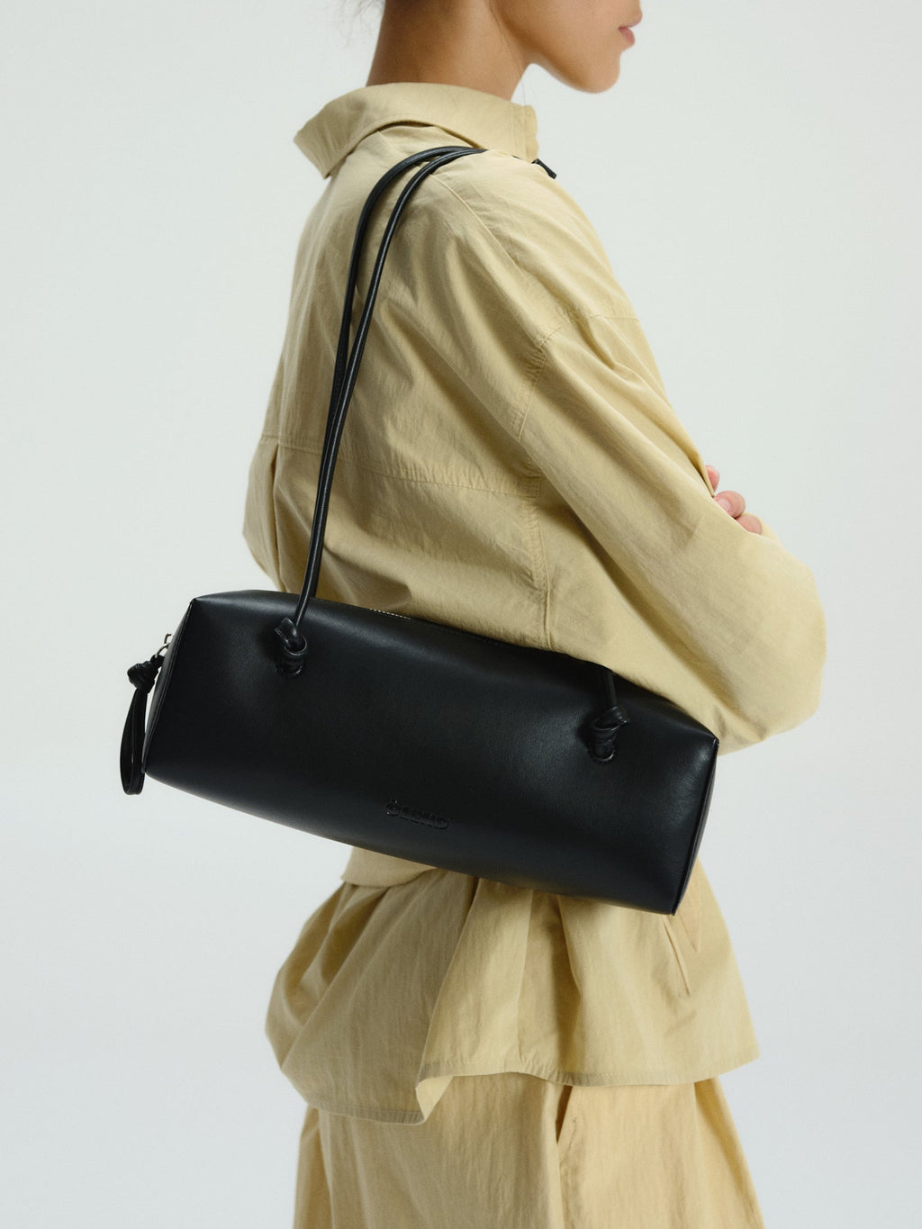 Sac à bandoulière compact en cuir végétalien de qualité supérieure, longues anses nouées, fermeture zippée