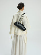 Sac à bandoulière compact en cuir végétalien de qualité supérieure, longues anses nouées, fermeture zippée