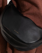 Sac bandoulière croissant noir, aspect cuir lisse
